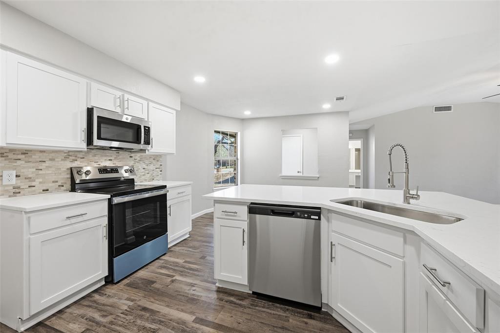 705 Timberoaks Drive Azle, TX 76020 - Photo 3 of 27 a kitchen with a sink stove and microwave