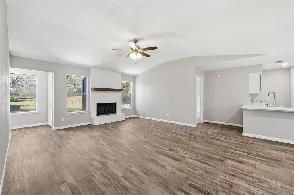 705 Timberoaks Drive Azle, TX 76020 - Photo 7 of 27 a view of an empty room with a fireplace and a window