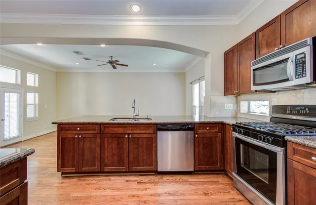 a view of kitchen with wooden floor and electronic appliances