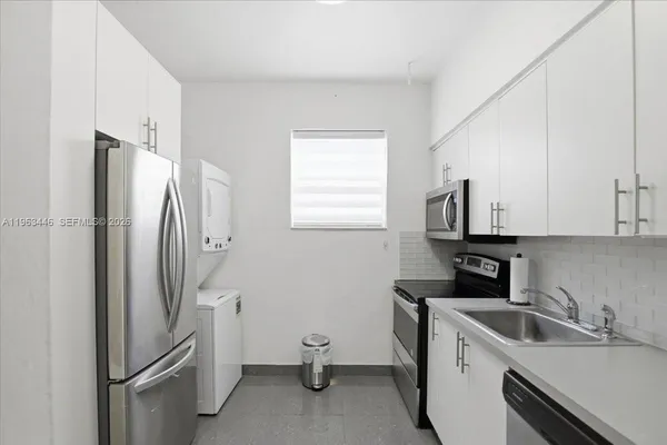 a kitchen with a refrigerator sink and cabinets