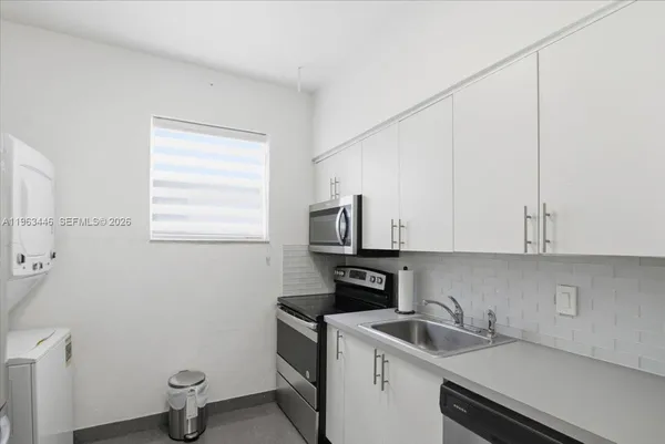 a view of a kitchen with sink and cabinets