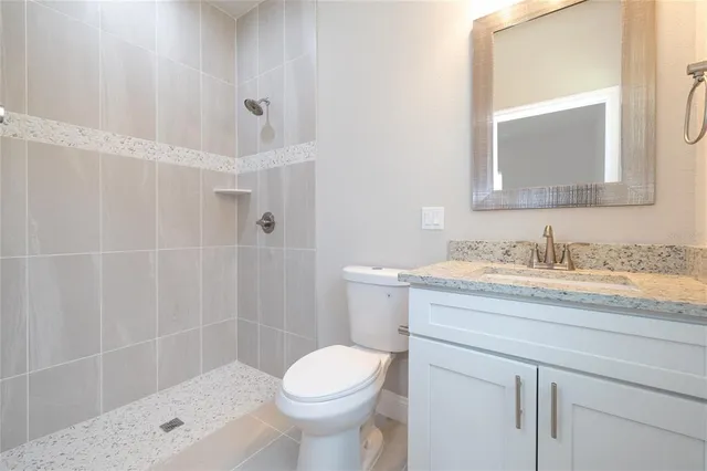a bathroom with a granite countertop sink toilet and shower