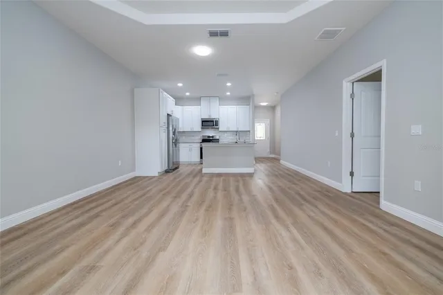 a view of a kitchen with a sink and wooden floor