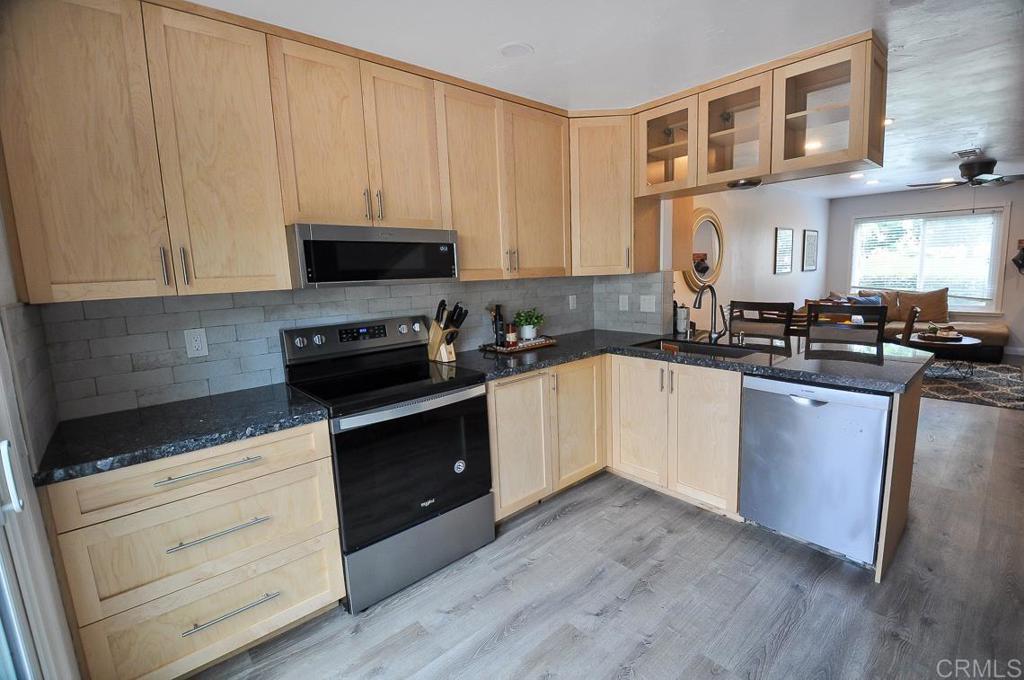 10155 Carefree Drive Santee, CA 92071 - Photo 7 of 19 a kitchen with granite countertop white cabinets and black appliances