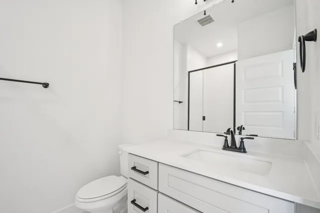 a bathroom with a sink a toilet and mirror