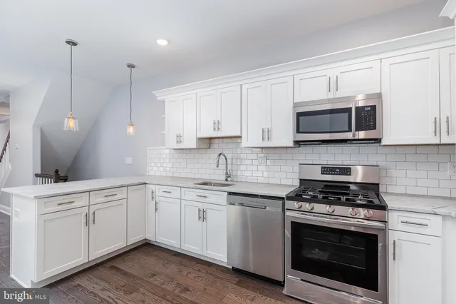 a kitchen with appliances a sink and cabinets