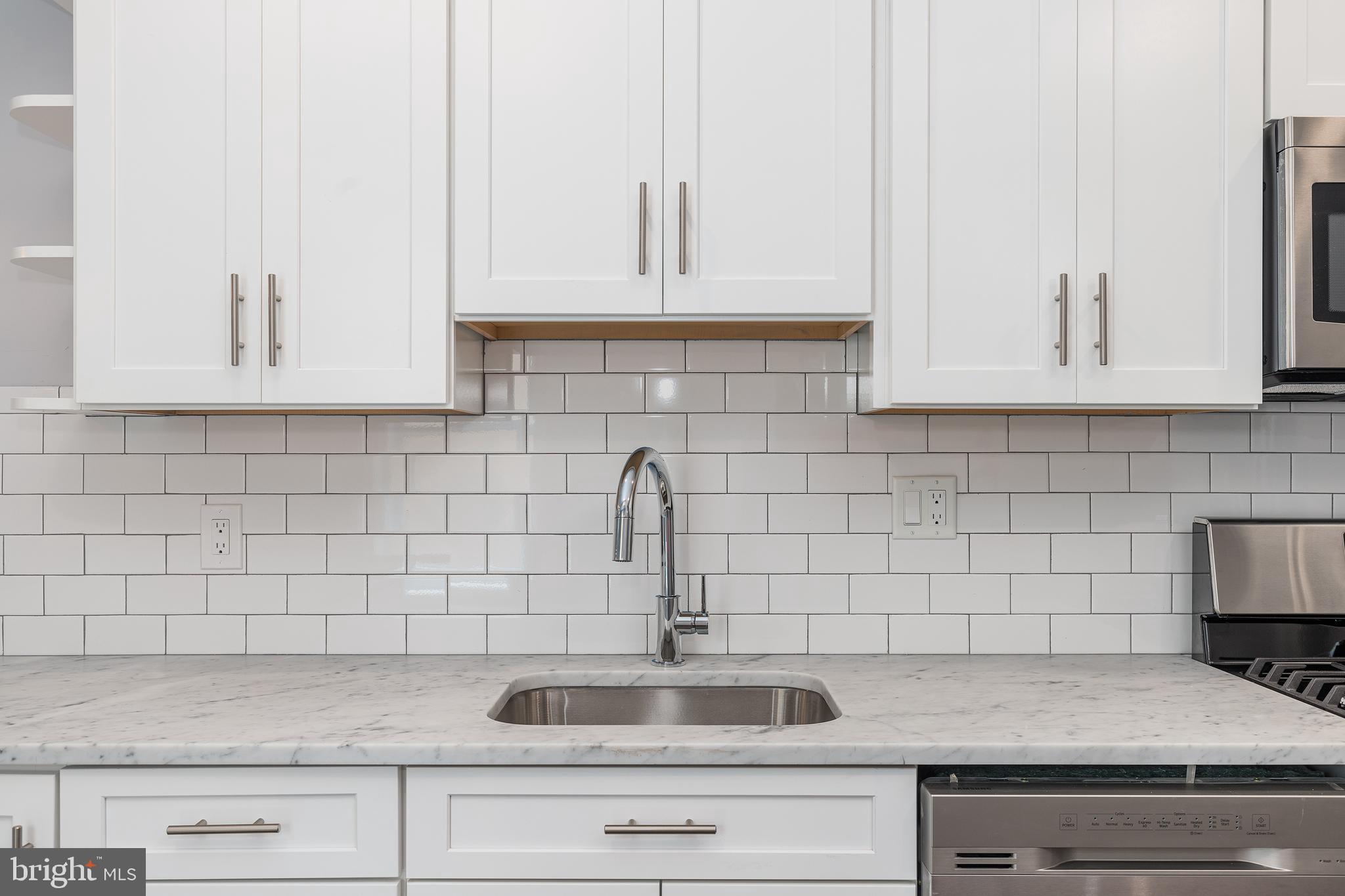 1701 Patapsco Street Baltimore, MD 21230 - Photo 14 of 52 a kitchen with white cabinets a sink and dishwasher