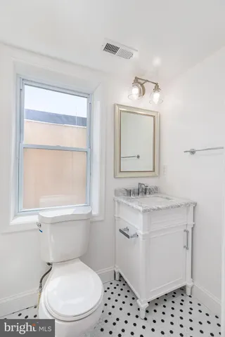 a bathroom with a sink a toilet and window
