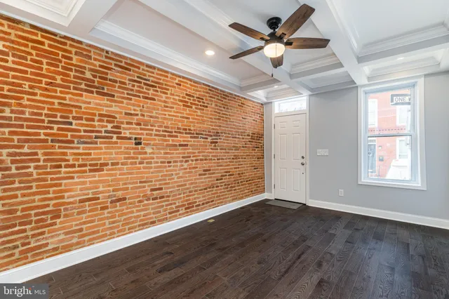 a view of an empty room with a window and a ceiling fan