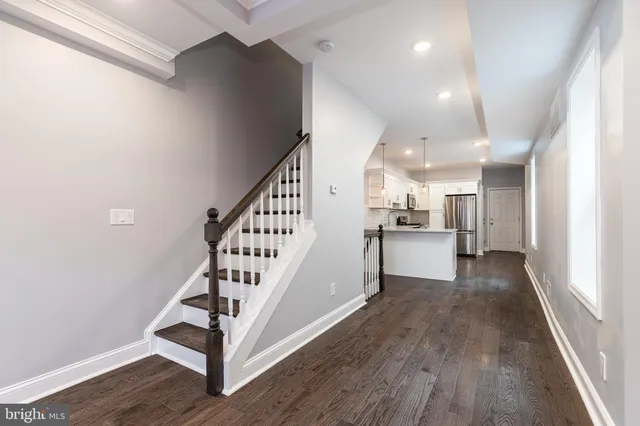 a view of a hallway with wooden floor and staircase