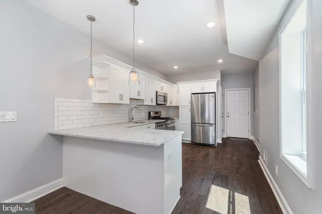 a kitchen with stainless steel appliances granite countertop a sink a stove and a refrigerator