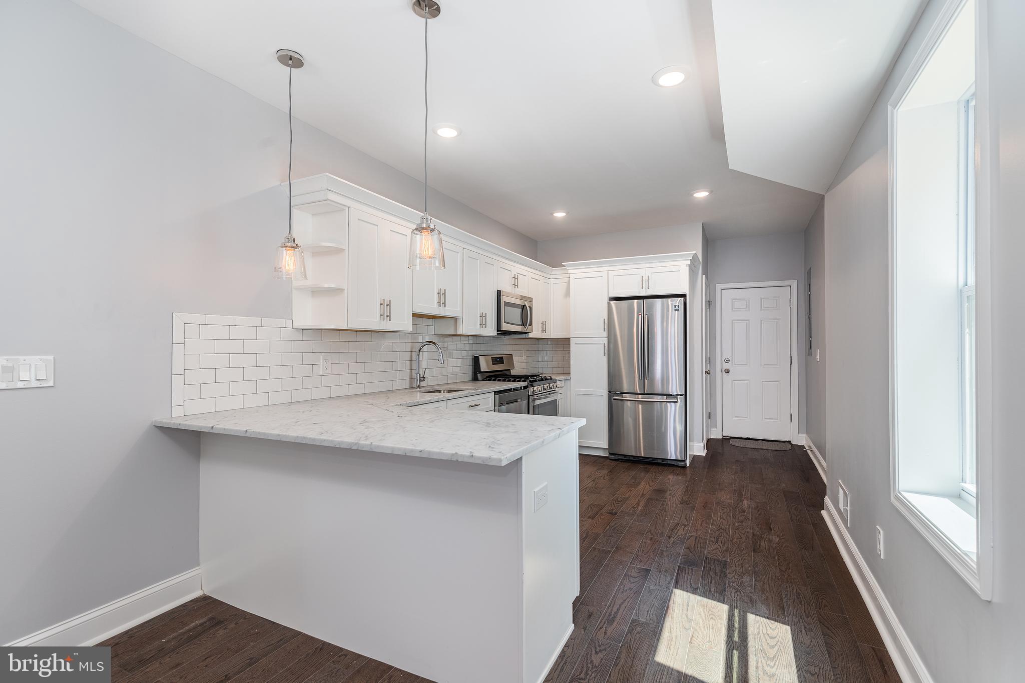 1701 Patapsco Street Baltimore, MD 21230 - Photo 9 of 52 a kitchen with stainless steel appliances granite countertop a sink a stove and a refrigerator