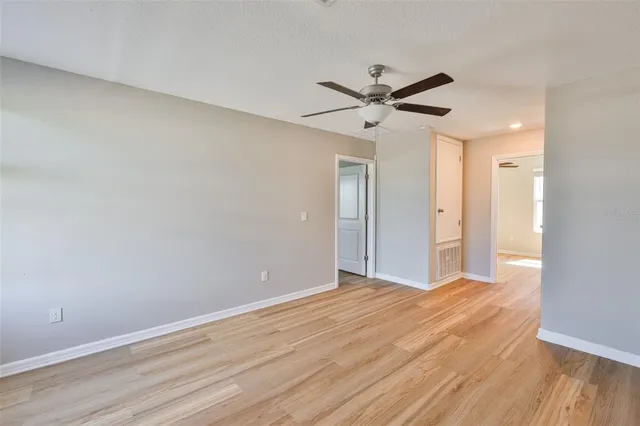 a view of empty room with wooden floor