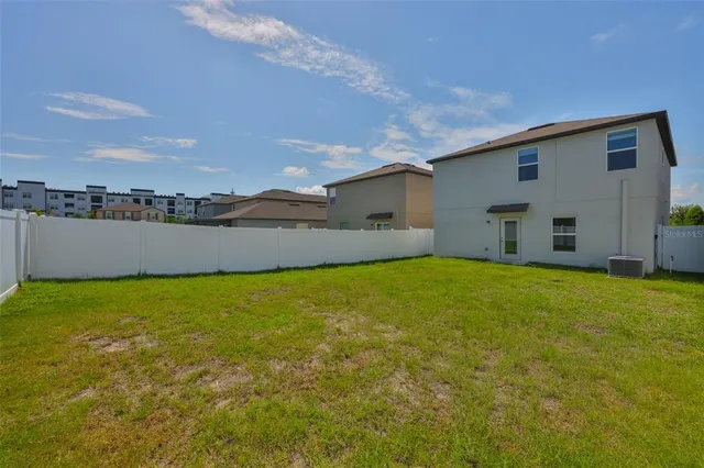 a view of a large pool with lawn chairs under an umbrella