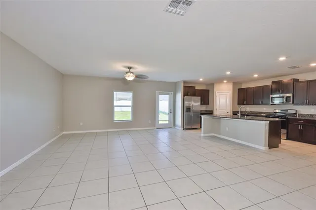 a large white kitchen with kitchen island granite countertop a sink and cabinets