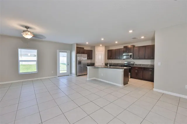 a large kitchen with a large counter top a stove a sink dishwasher and a refrigerator