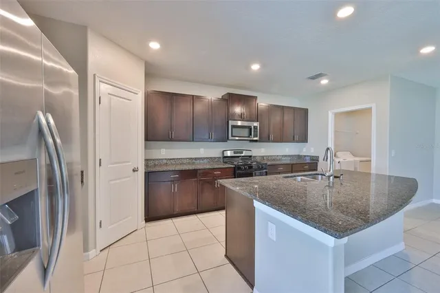 a kitchen with stainless steel appliances granite countertop a sink stove and refrigerator