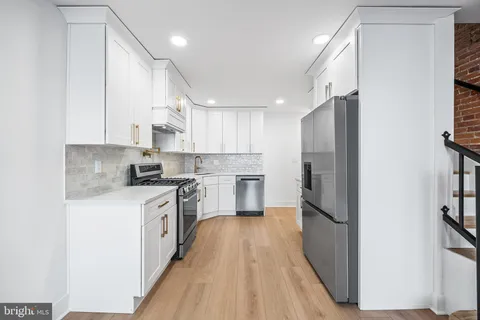 a kitchen with stainless steel appliances a refrigerator sink and cabinets