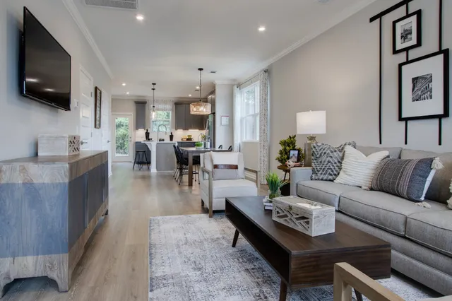 a living room with furniture kitchen view and a flat screen tv