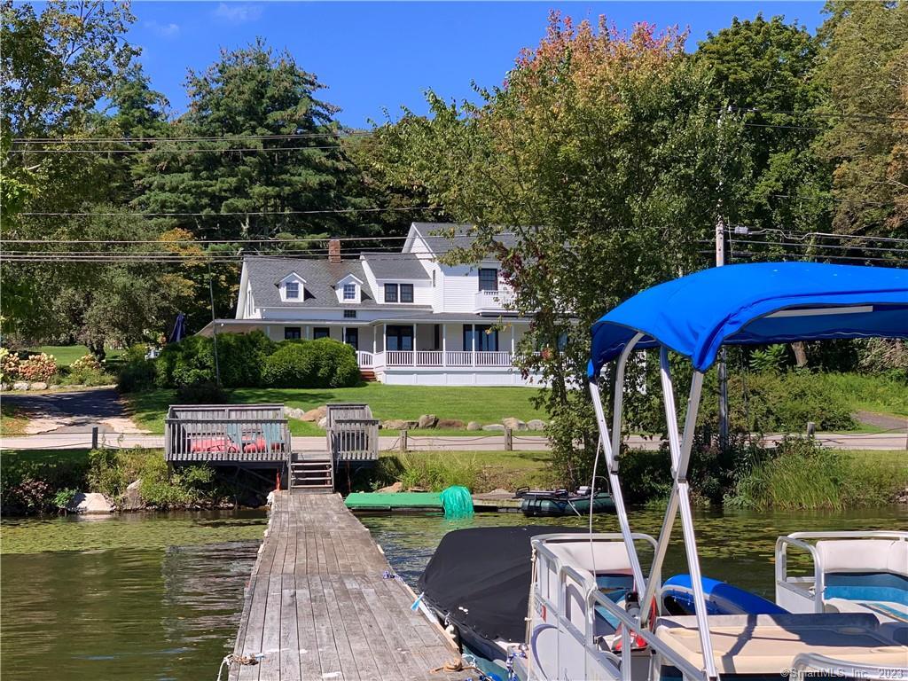 105 Bantam Lake Road Morris, CT 06763 - Photo 1 of 1 a view of a rooftop with a table and chairs under an umbrella with large trees