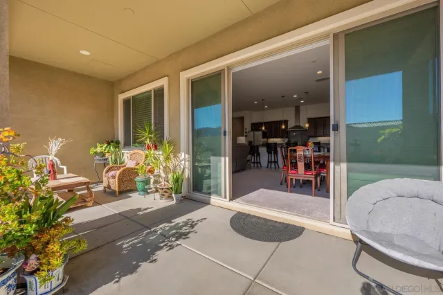 a view of a hallway with dining area and glass windows