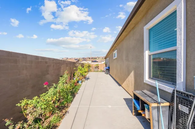 a backyard of a house with table and chairs plants