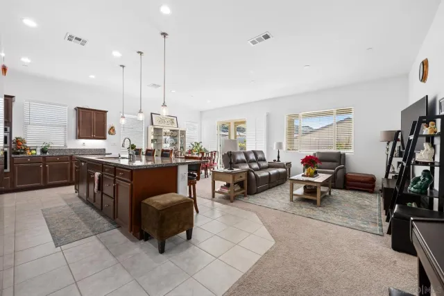 a large kitchen with kitchen island granite countertop a sink counter top space appliances and cabinets