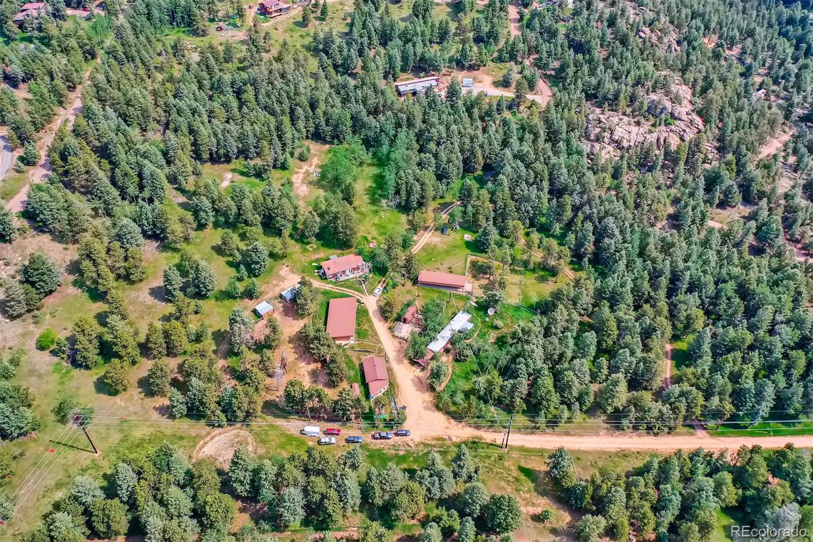 an aerial view of residential house with outdoor space and trees all around