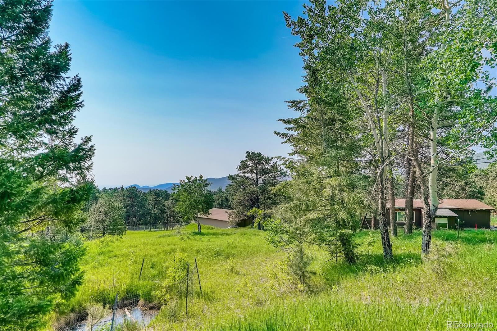 8939 South Hillview Road Morrison, CO 80465 - Photo 22 of 39 a big yard with lots of green space and plants