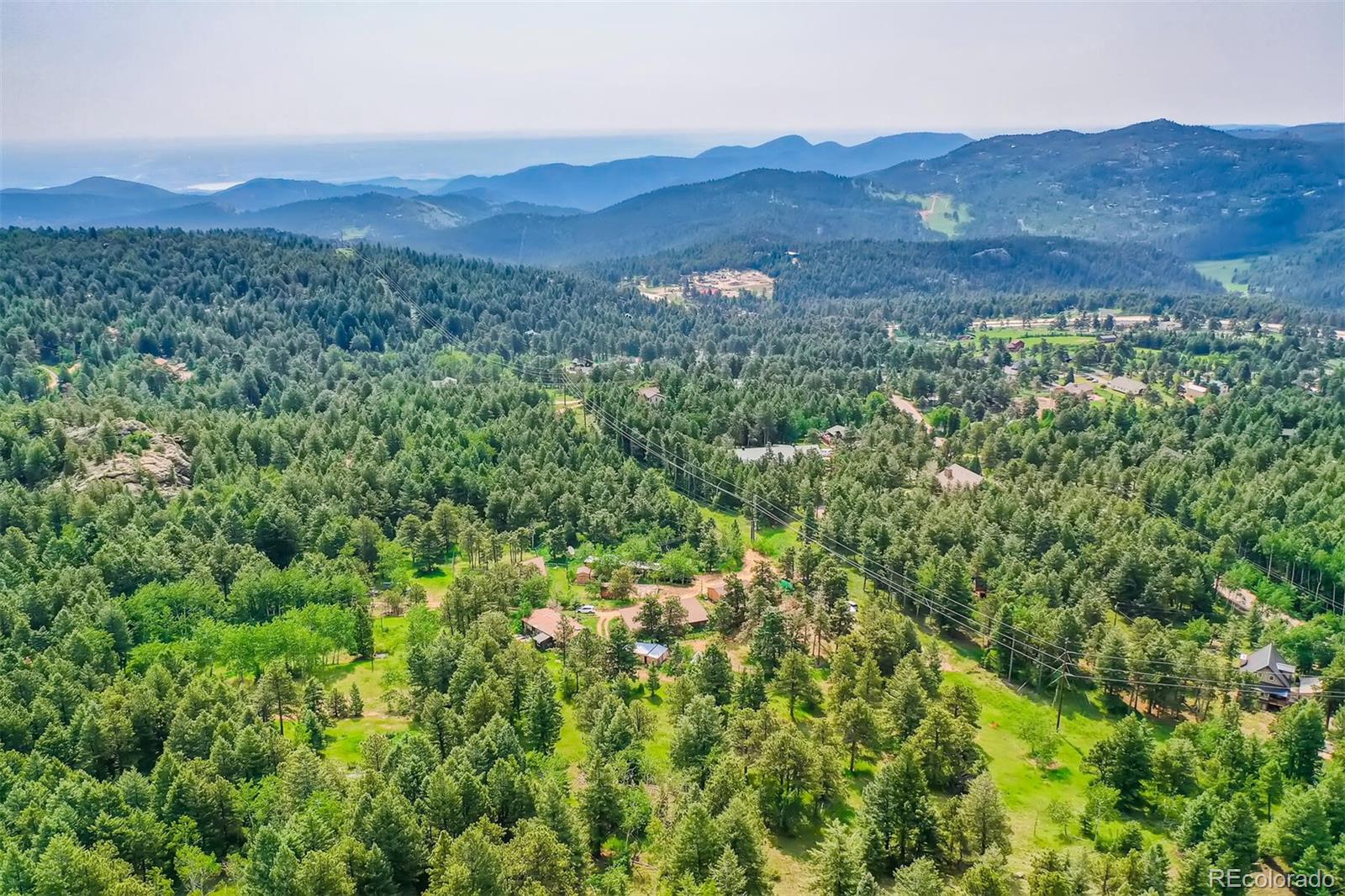 8939 South Hillview Road Morrison, CO 80465 - Photo 5 of 39 a view of a lush green hillside and a houses