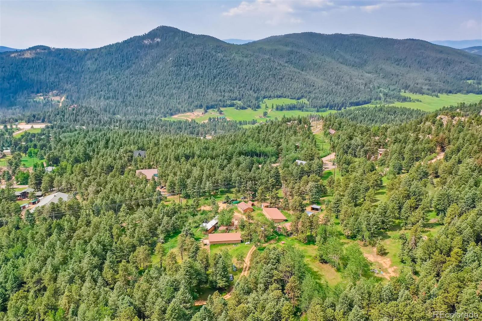 8939 South Hillview Road Morrison, CO 80465 - Photo 6 of 39 a view of a lush green hillside and a building
