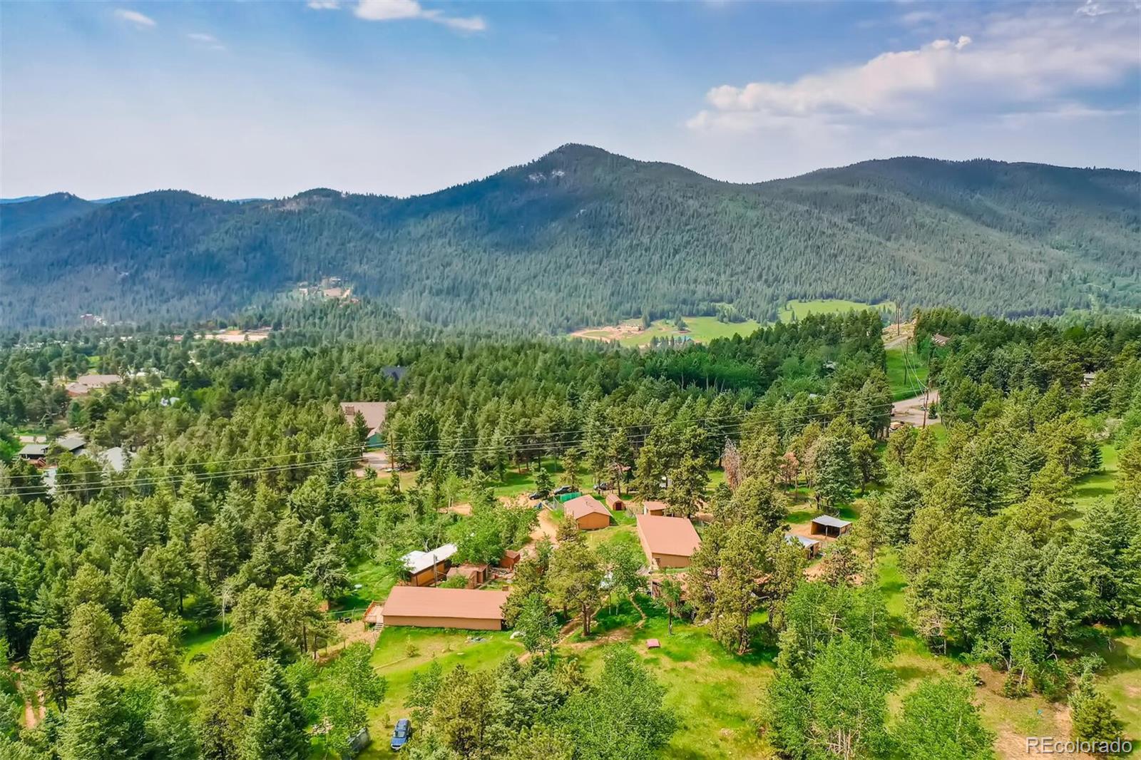 8939 South Hillview Road Morrison, CO 80465 - Photo 7 of 39 a backyard of a house with large trees and plants