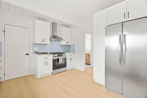 a kitchen with white cabinets and stainless steel appliances