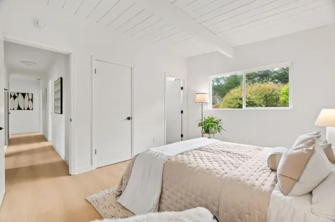 a bedroom with a bed and a painting on the wall