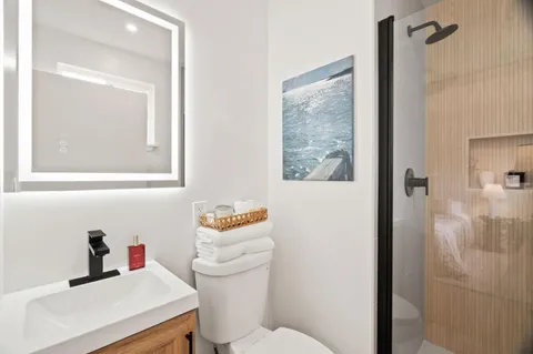 a bathroom with a sink vanity mirror and toilet