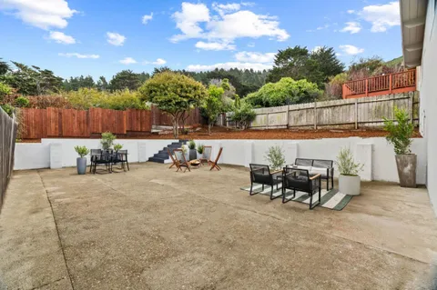 a view of a patio with table and chairs and potted plants