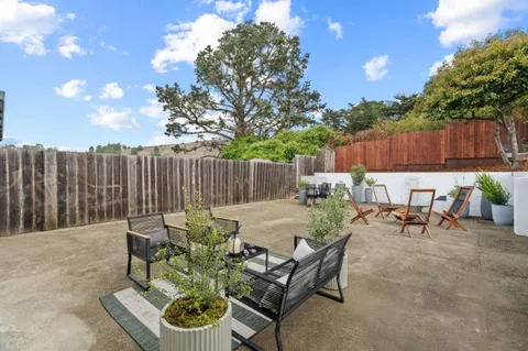 a backyard of a house with table and chairs