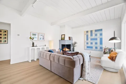a living room with furniture a fireplace and a large window