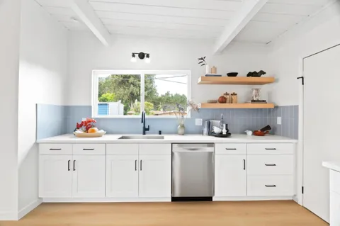 a kitchen with a stove a window and cabinets