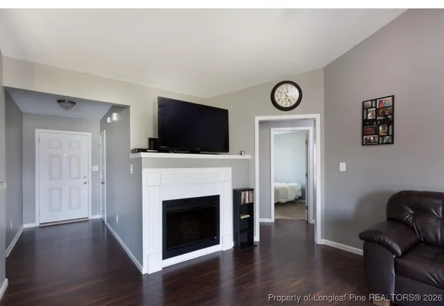 a living room with furniture a fireplace and a flat screen tv