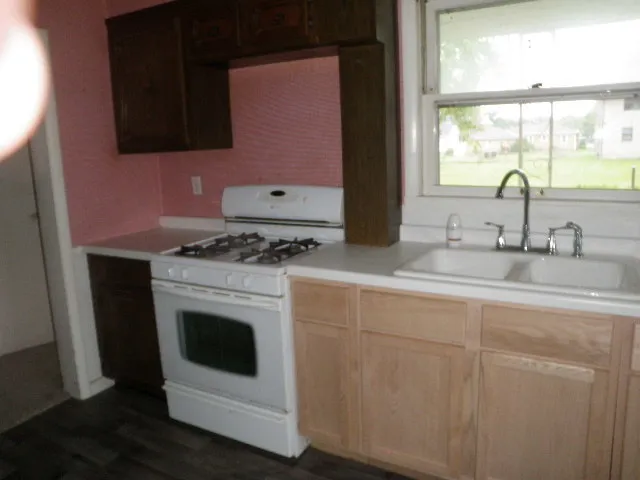 a kitchen with granite countertop a stove sink and microwave