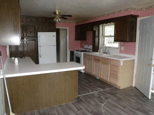a kitchen with sink a refrigerator and cabinets