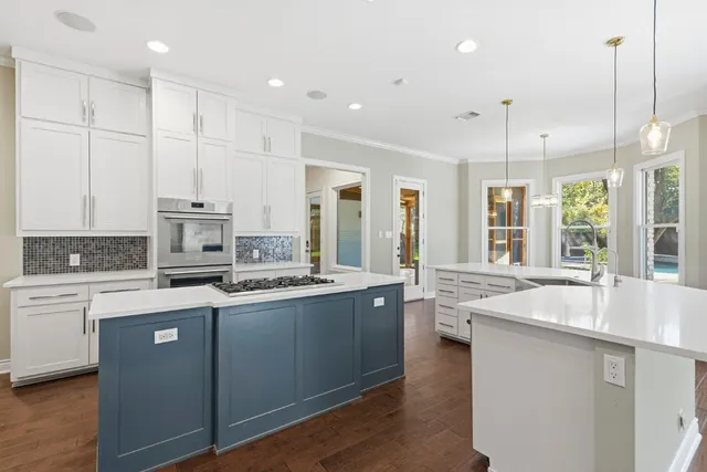 a kitchen that has a refrigerator a sink and white cabinets