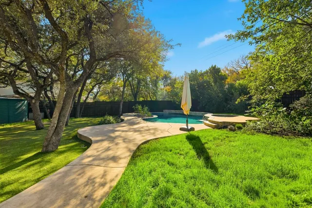 a view of a house with swimming pool and a yard