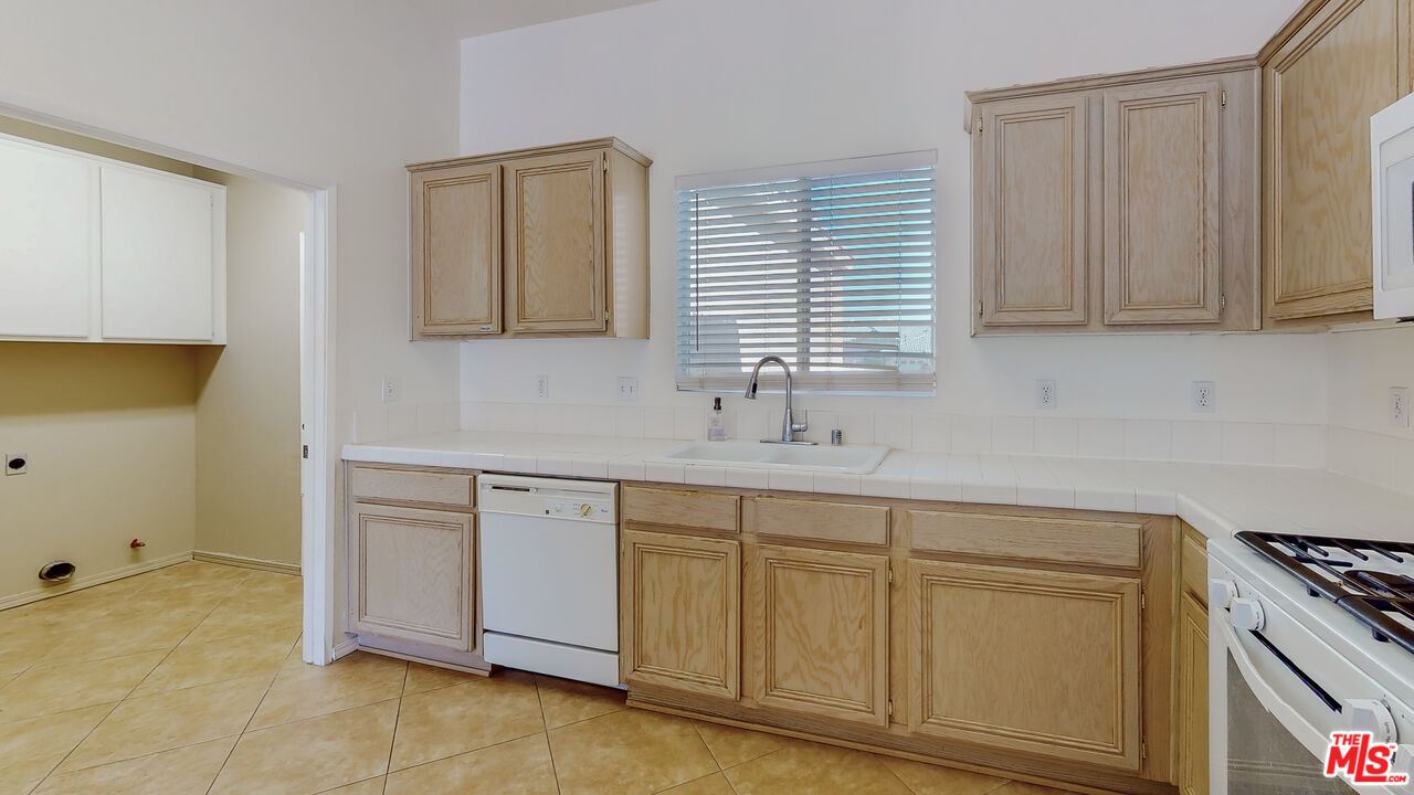 68606 La Medera Road Cathedral City, CA 92234 - Photo 8 of 33 a kitchen with white cabinets and a sink