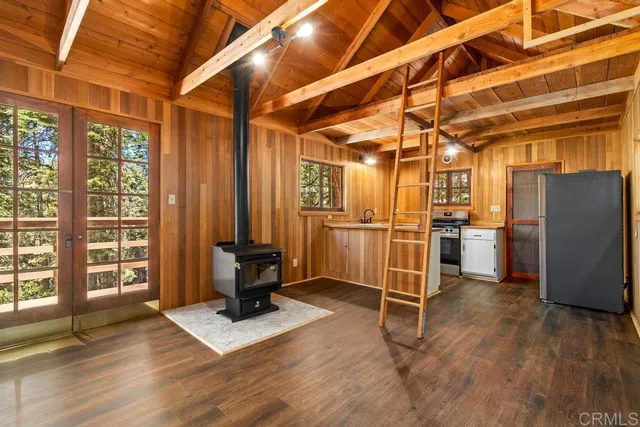 a kitchen with stainless steel appliances wooden floor and a refrigerator