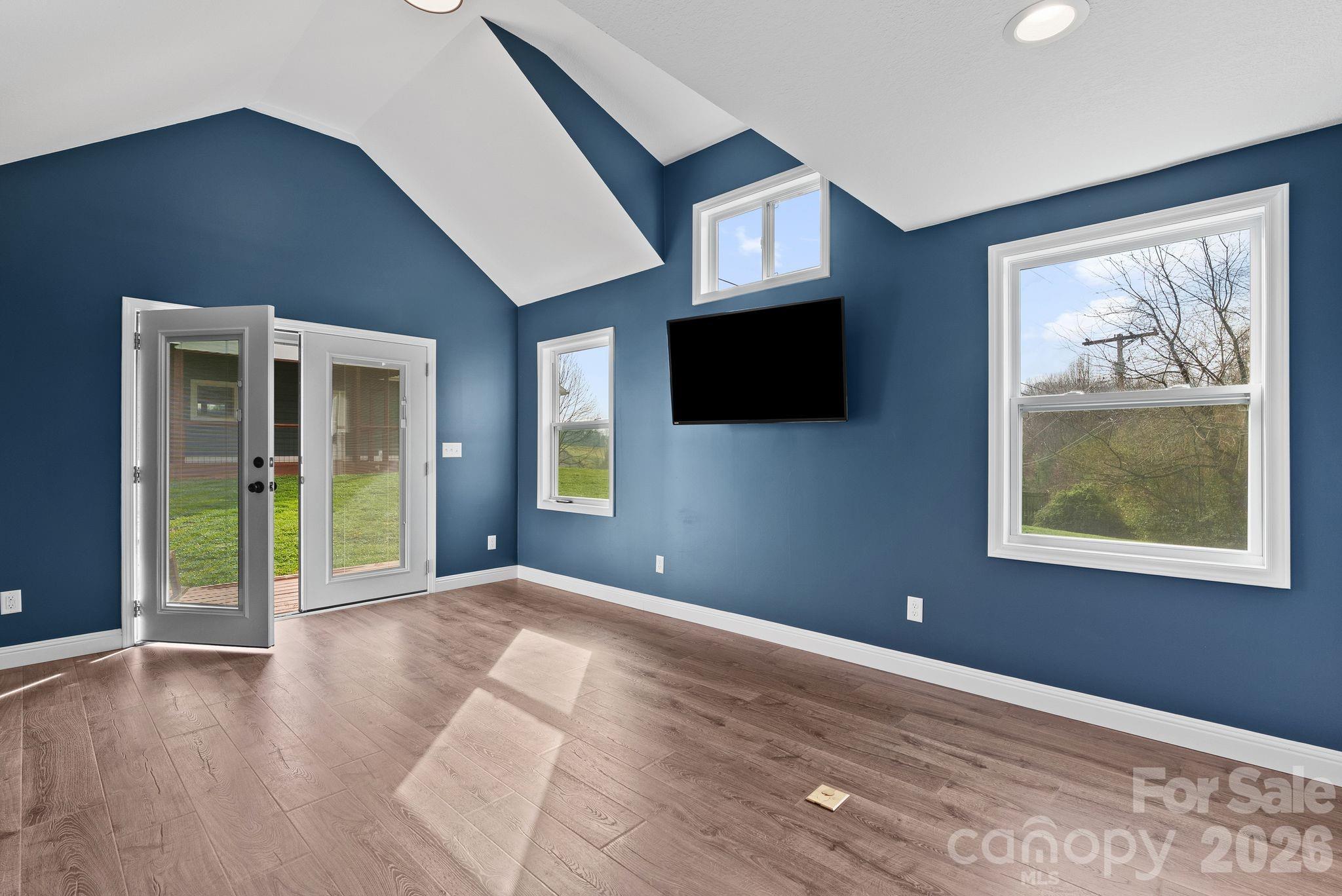 209 Breton Ridge Road Leicester, NC 28748 - Photo 21 of 34 a view of an empty room with a window and a flat screen tv