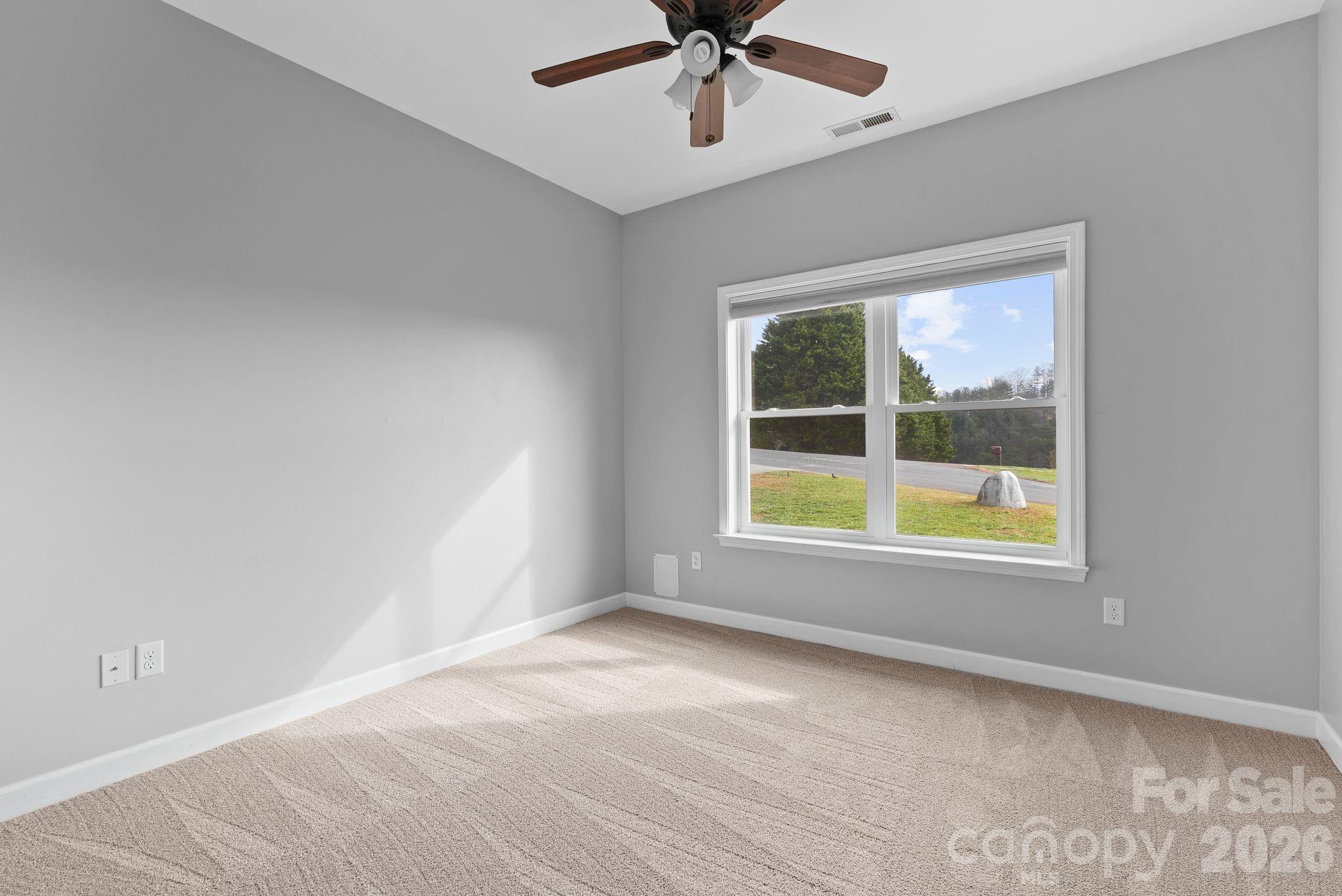 209 Breton Ridge Road Leicester, NC 28748 - Photo 9 of 34 an empty room with a window and a ceiling fan