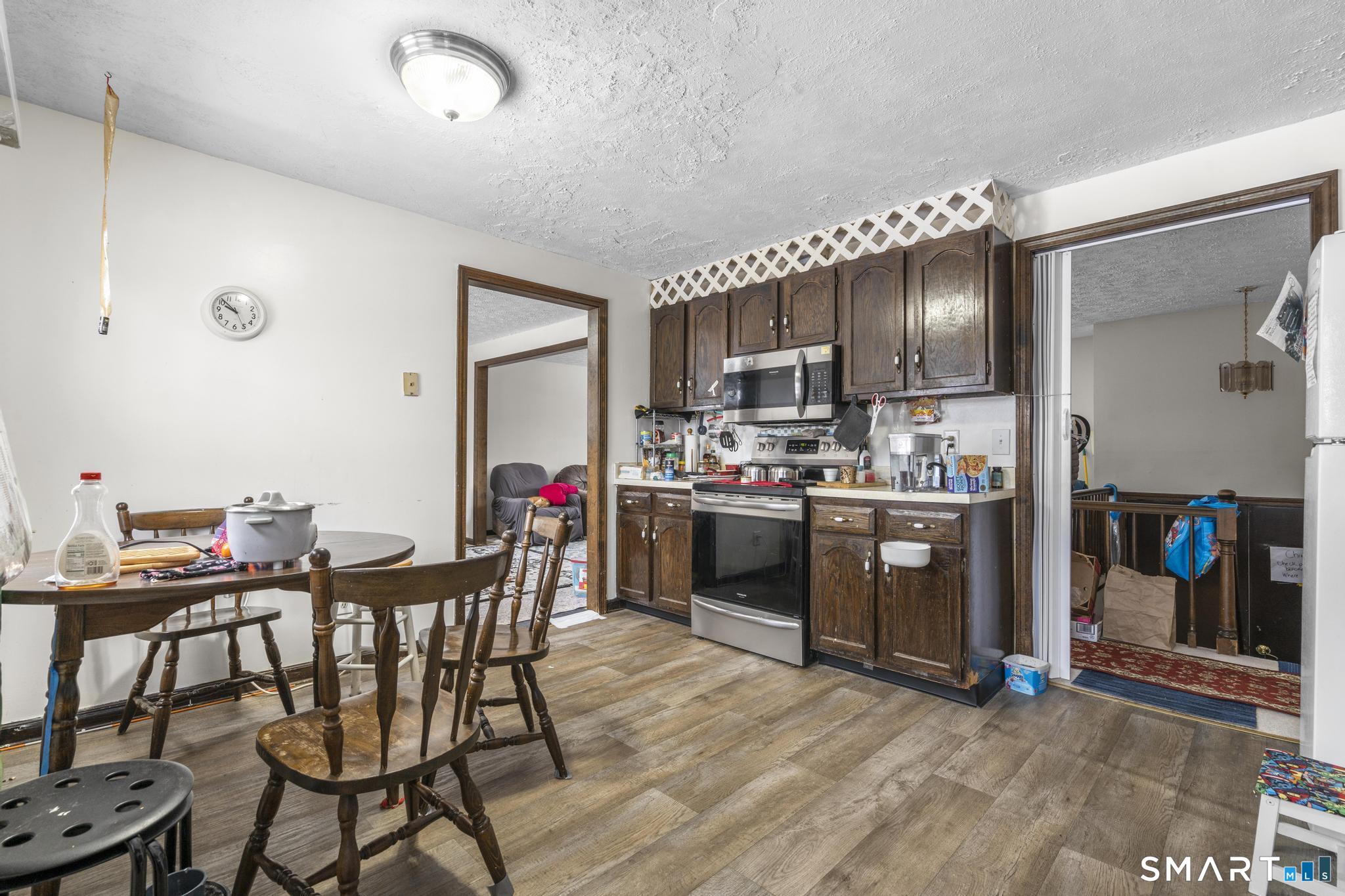 133 Stevenson Road Meriden, CT 06451 - Photo 13 of 30 a kitchen with stainless steel appliances a table chairs and a refrigerator