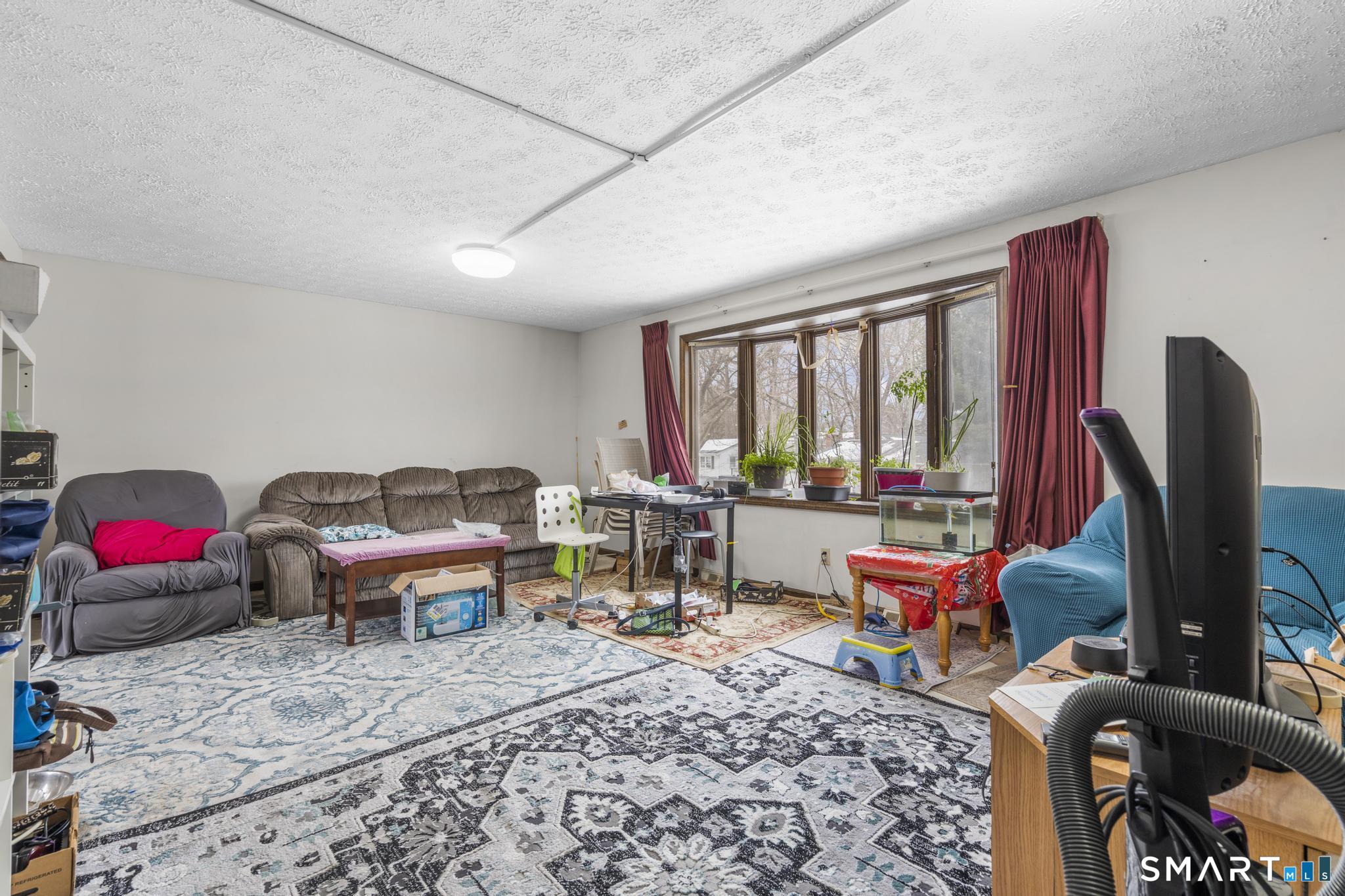133 Stevenson Road Meriden, CT 06451 - Photo 8 of 30 a living room with furniture a rug and a floor to ceiling window